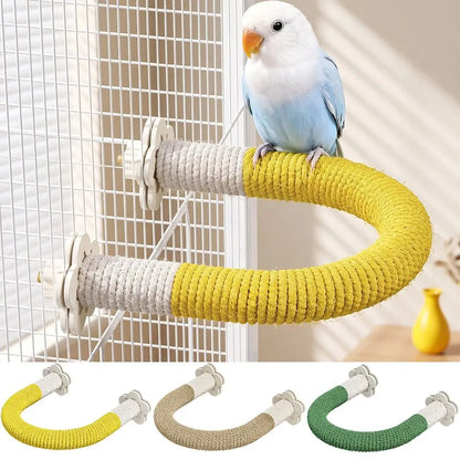 A small blue-and-white bird perched on a curved rope bird perch mounted on a wire cage. The perch has a yellow and off-white rope wrap with white plastic mounting hardware.