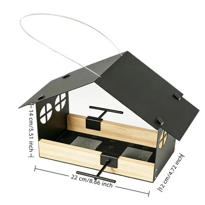 A house-shaped bird feeder with a black metal roof and frame, light natural wood sides, and a clear front panel, shown on a white background with dimension lines and text indicating measurements.