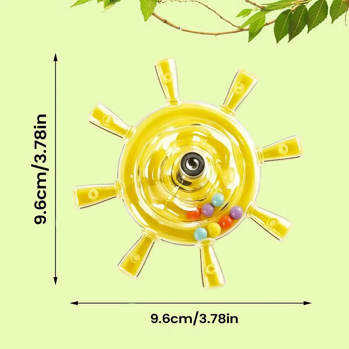 A yellow transparent circular bird toy measurement arrows and text indicating 9.6 cm / 3.