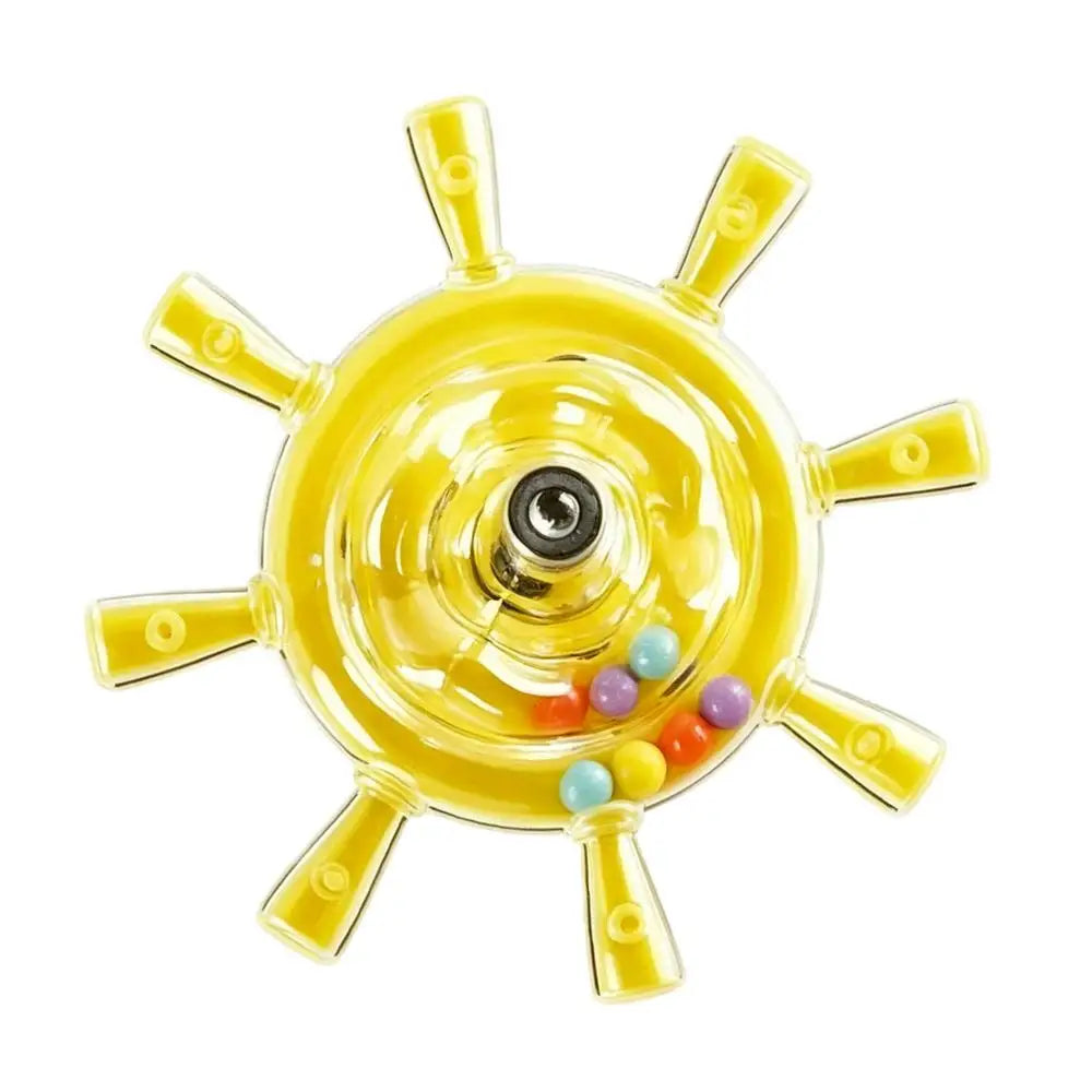 A yellow ship's wheel toy with a clear plastic center, a metal axle, and small multicolored beads inside, shown on a plain white background.